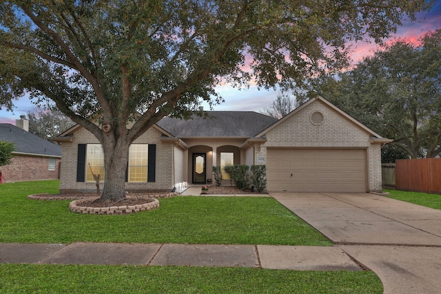 ranch-style house with brick siding, an attached garage, fence, a yard, and driveway