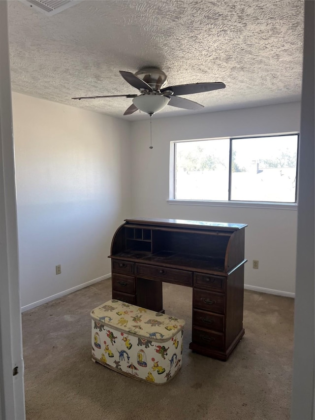 carpeted office with a ceiling fan, baseboards, and a textured ceiling