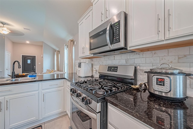 kitchen featuring visible vents, a sink, appliances with stainless steel finishes, white cabinetry, and backsplash