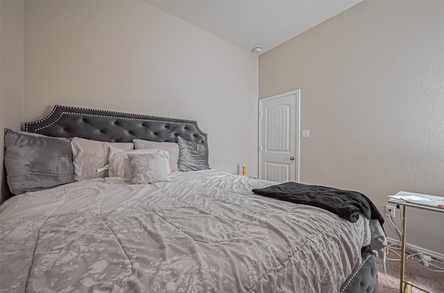 bedroom featuring baseboards and lofted ceiling