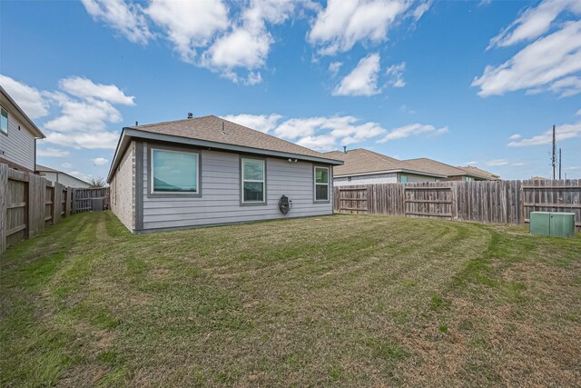 rear view of property with a yard and a fenced backyard