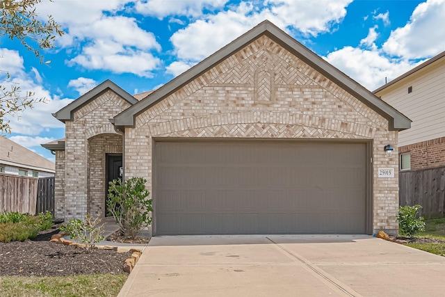 french country style house with fence, brick siding, and a garage