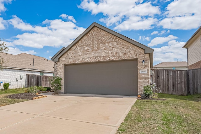 view of front of house with a front yard, fence, an attached garage, concrete driveway, and brick siding