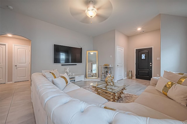 living room featuring light tile patterned floors, visible vents, and ceiling fan