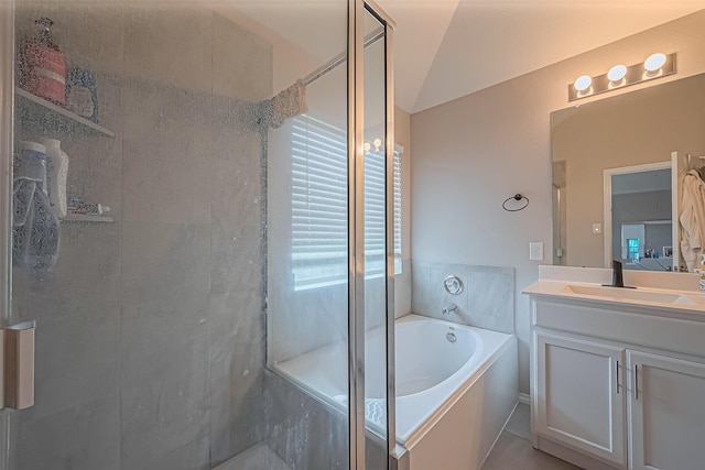 bathroom featuring vanity, a shower stall, a bath, and vaulted ceiling