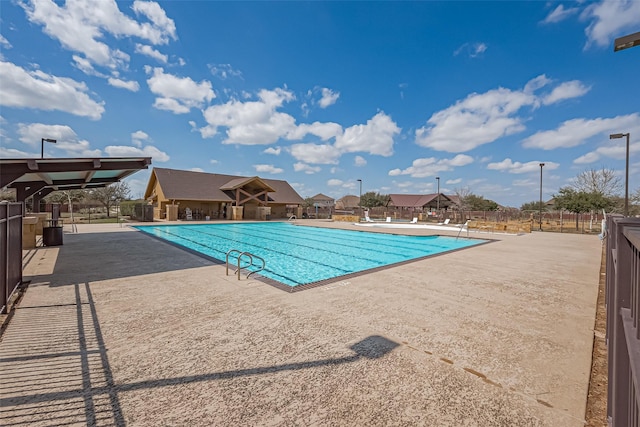 community pool featuring a patio area and fence