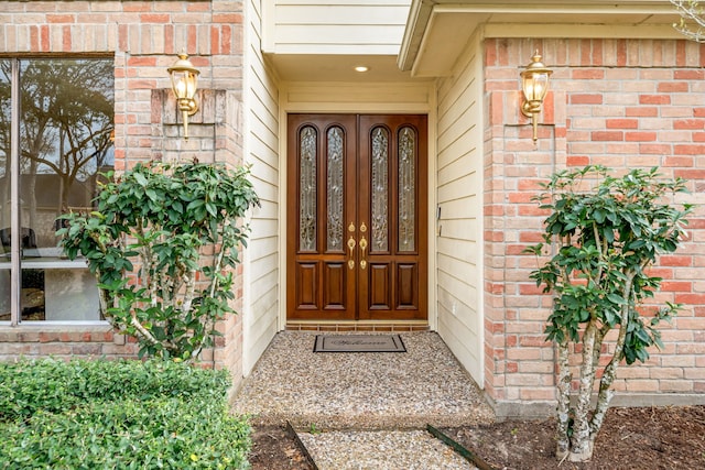 doorway to property featuring brick siding