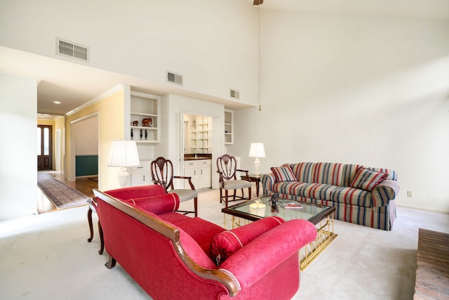 living area with visible vents, light carpet, and ornamental molding