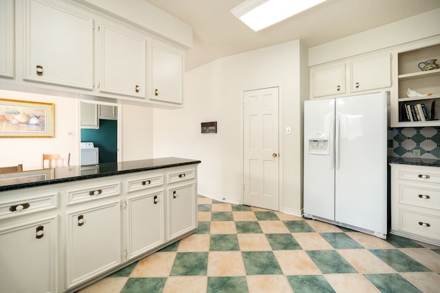 kitchen featuring light floors, dark stone counters, white refrigerator with ice dispenser, white cabinets, and open shelves