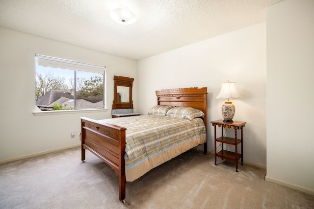 bedroom featuring baseboards, carpet floors, and a textured ceiling