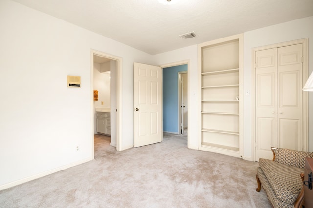 unfurnished bedroom featuring carpet, visible vents, a closet, and baseboards