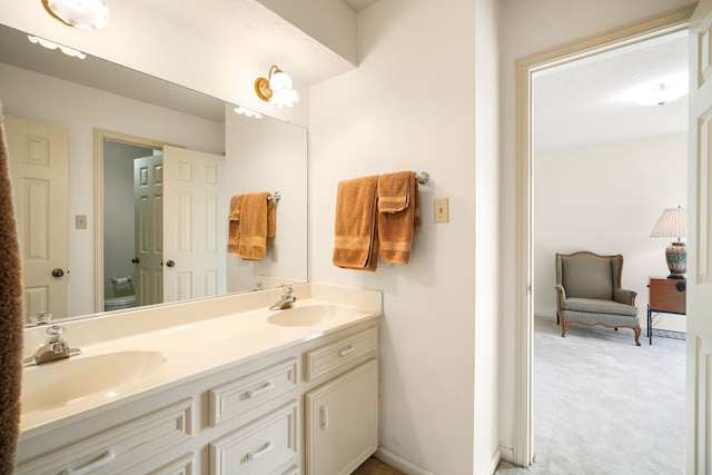 bathroom featuring a sink, baseboards, and double vanity