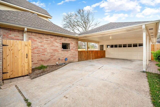 12215 Clearfork Dr, Houston, TX 77077 - view of side of home featuring roof with shingles, fence, driveway, and brick siding