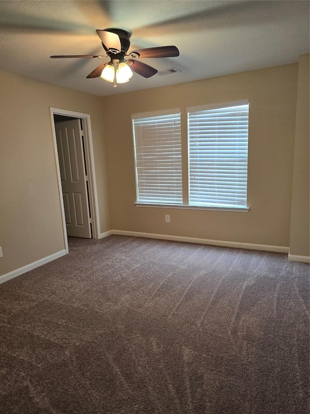 empty room featuring a ceiling fan, carpet, visible vents, and baseboards