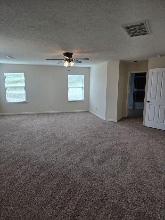 spare room featuring a wealth of natural light, visible vents, and carpet