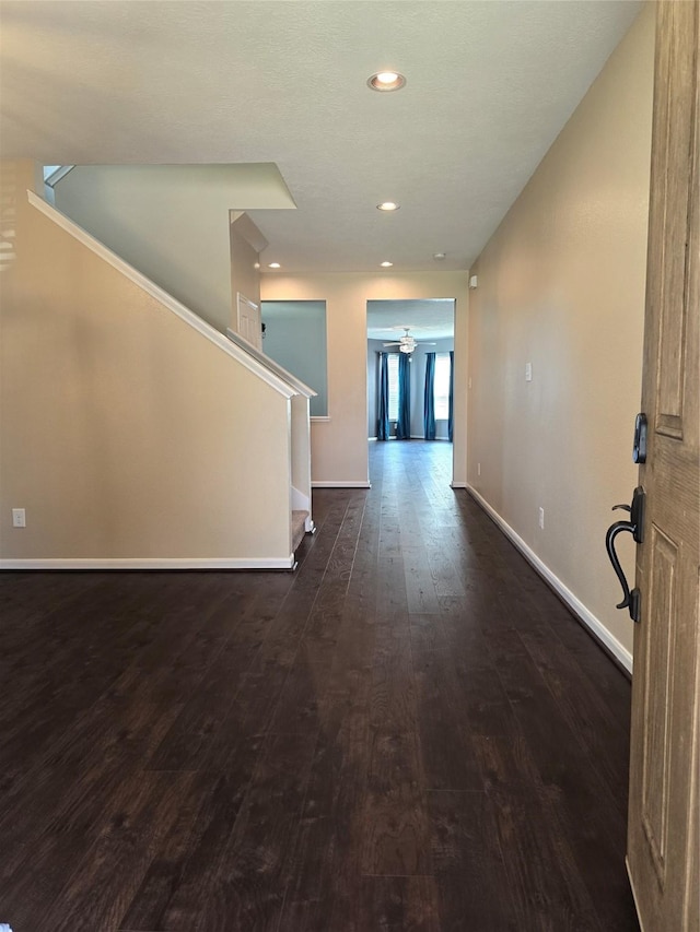 hallway featuring dark wood-style flooring, recessed lighting, and baseboards