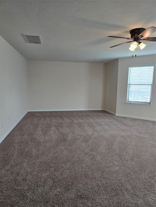 unfurnished room featuring carpet floors, baseboards, visible vents, and ceiling fan