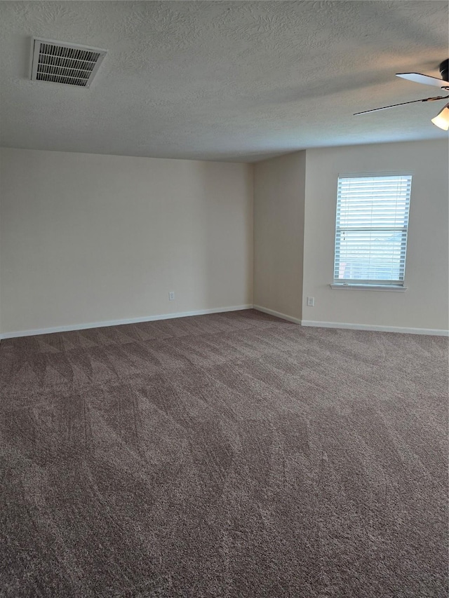 carpeted empty room with baseboards, a textured ceiling, visible vents, and a ceiling fan