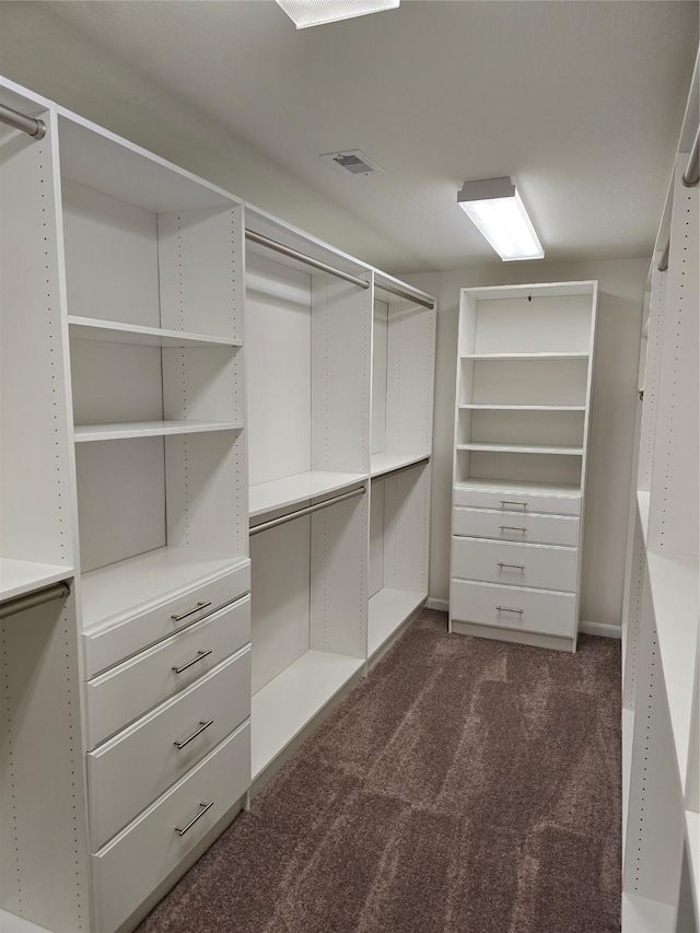 walk in closet with visible vents and dark colored carpet