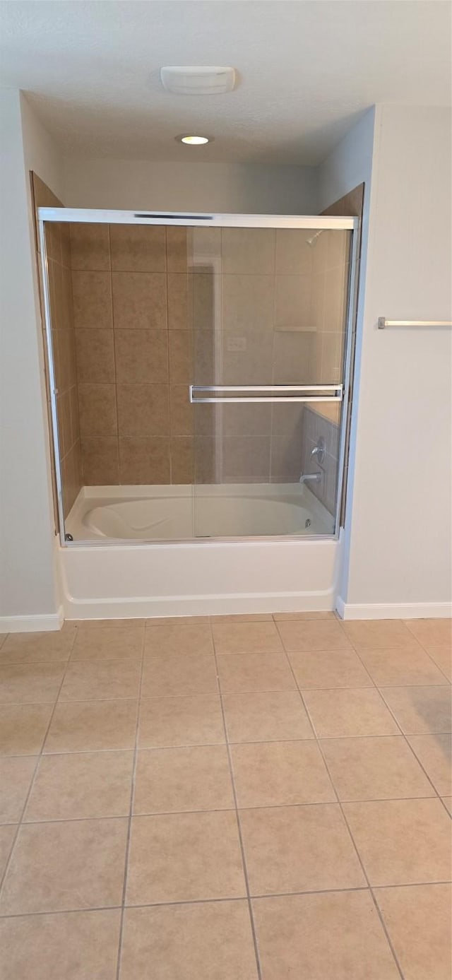 full bathroom featuring tile patterned floors, baseboards, and shower / bath combination with glass door