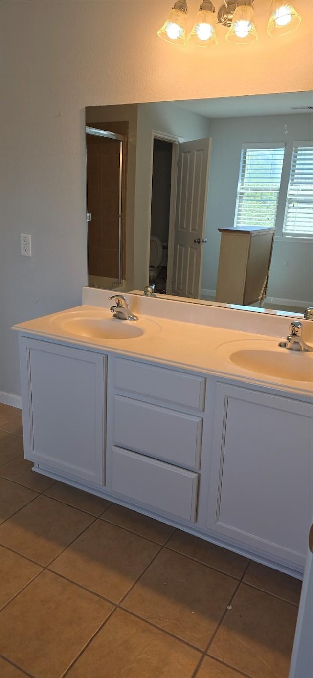 bathroom with tile patterned floors, double vanity, and a sink