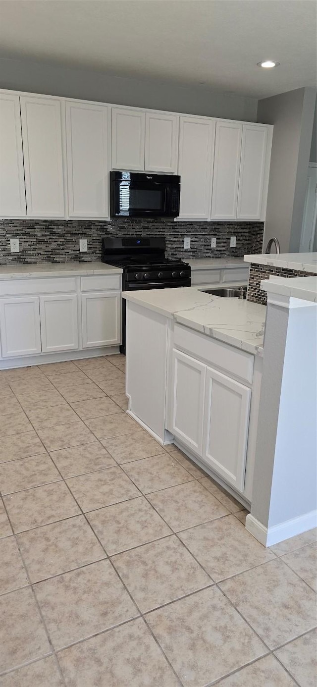 kitchen featuring backsplash, white cabinets, light tile patterned floors, and black appliances