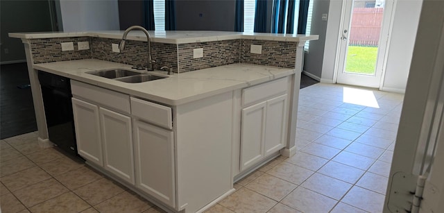 kitchen featuring backsplash, black dishwasher, a sink, and light tile patterned floors