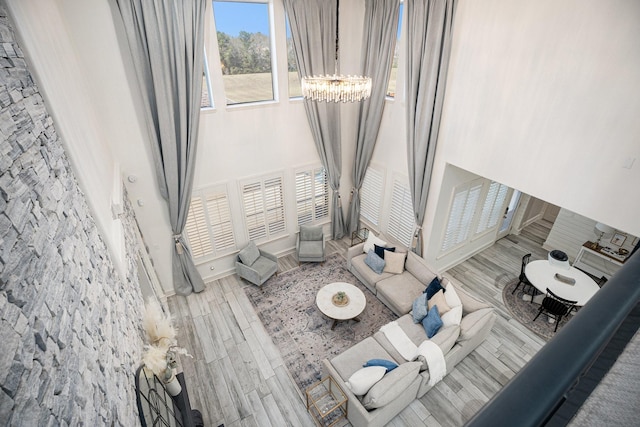 living area with baseboards, a chandelier, and wood tiled floor