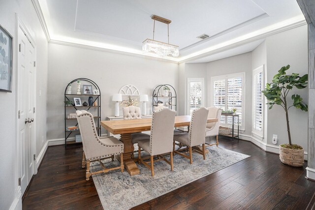 dining room featuring visible vents, dark wood-type flooring, and a tray ceiling