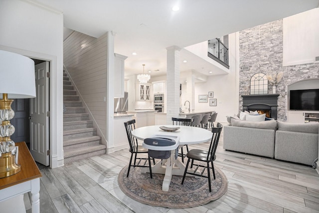 dining space featuring stairs, recessed lighting, a fireplace, and wood finish floors