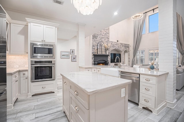 kitchen with a sink, a kitchen island, tasteful backsplash, open floor plan, and stainless steel appliances