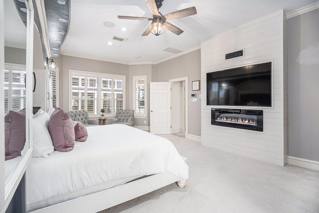 carpeted bedroom with visible vents, baseboards, a fireplace, and crown molding