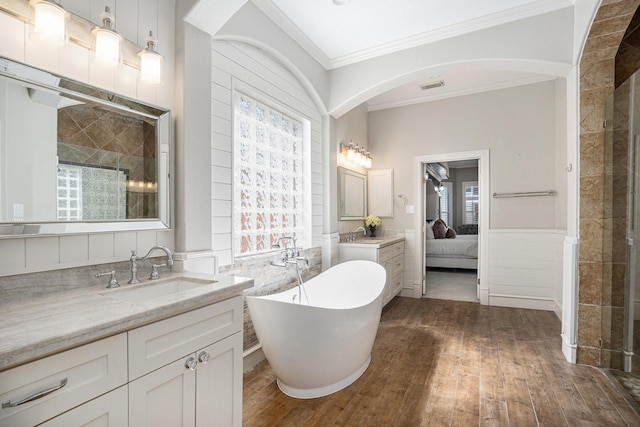 bathroom featuring crown molding, wood finished floors, visible vents, and wainscoting