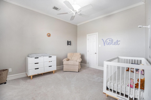 bedroom featuring baseboards, visible vents, ornamental molding, a crib, and light carpet