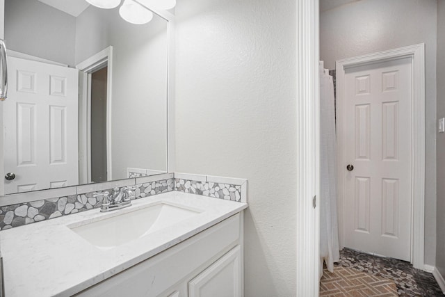 full bathroom with vanity and brick floor