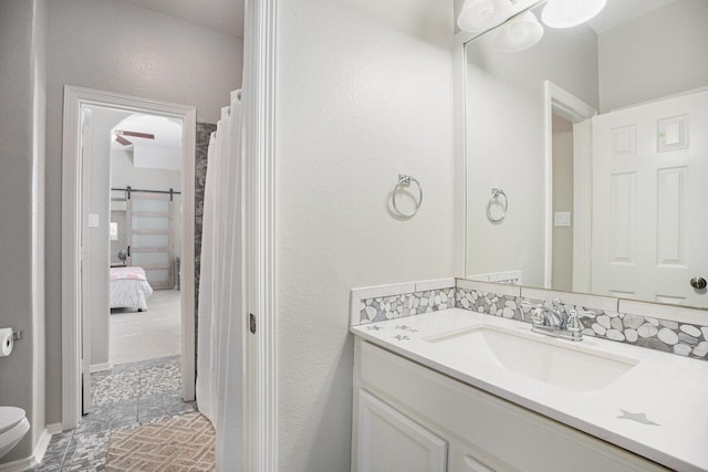 ensuite bathroom featuring toilet, ensuite bath, and vanity