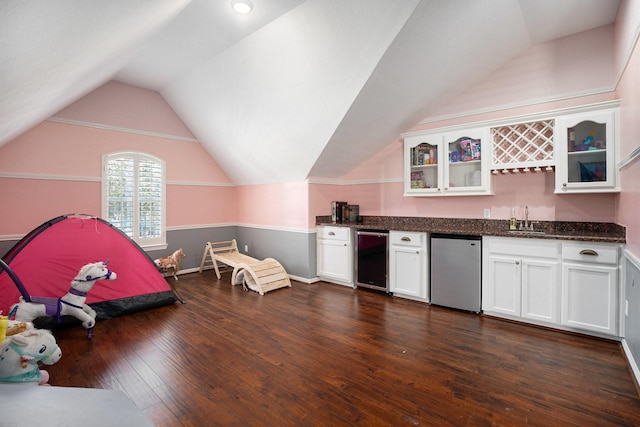 interior space featuring beverage cooler, a sink, dark wood-style floors, fridge, and glass insert cabinets