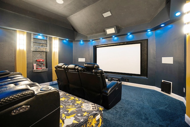 home theater room featuring baseboards, lofted ceiling, and carpet