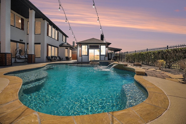 pool at dusk with a fenced in pool, an exterior structure, a fenced backyard, an outdoor structure, and a patio area