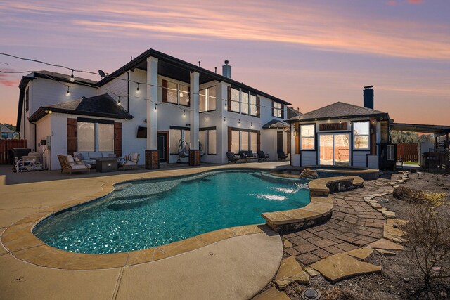 view of pool featuring a pool with connected hot tub, fence, a gazebo, outdoor lounge area, and a patio area