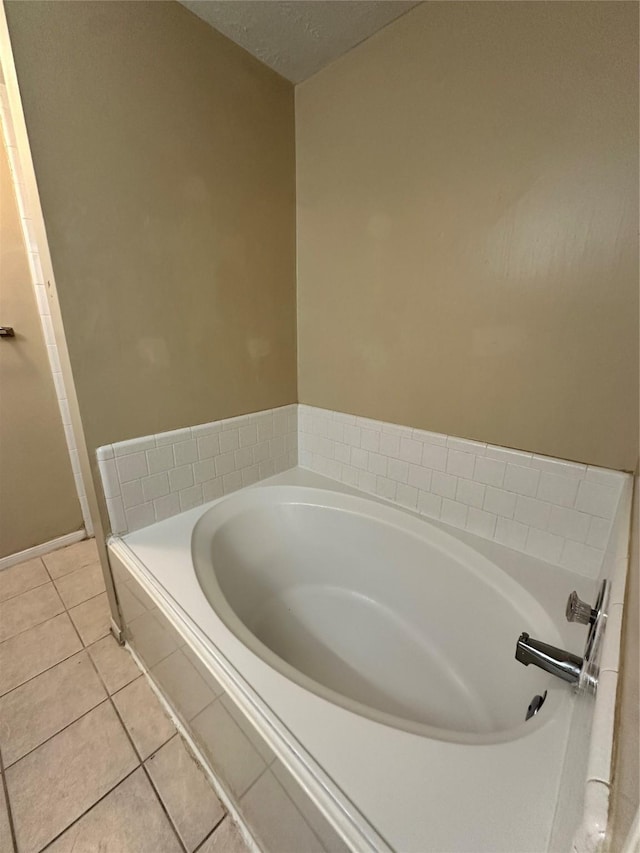 bathroom featuring a textured ceiling, a bath, and tile patterned flooring