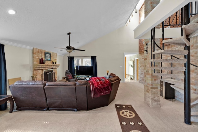 carpeted living area featuring ceiling fan, ornamental molding, a textured ceiling, a brick fireplace, and high vaulted ceiling