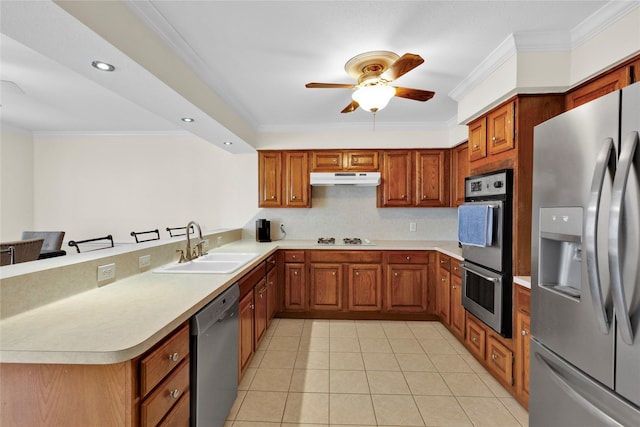 kitchen featuring under cabinet range hood, a sink, light countertops, appliances with stainless steel finishes, and crown molding