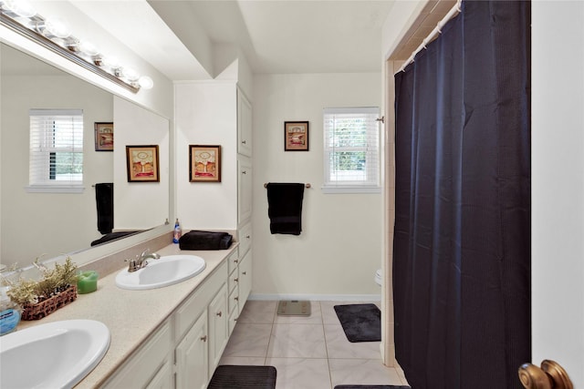 full bathroom featuring toilet, a sink, baseboards, tile patterned floors, and double vanity