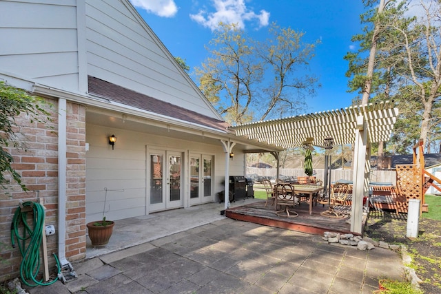 view of patio with fence, outdoor dining area, a pergola, and french doors