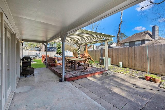 view of patio / terrace with a fenced backyard, outdoor dining area, a pergola, and an outbuilding