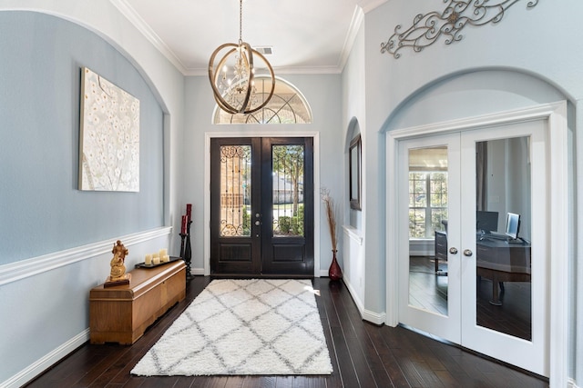 entryway with french doors, dark wood-style flooring, crown molding, an inviting chandelier, and baseboards