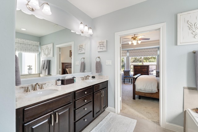 bathroom featuring tile patterned flooring, double vanity, a sink, and ensuite bathroom