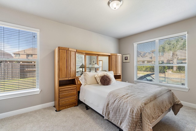 bedroom featuring baseboards and light colored carpet