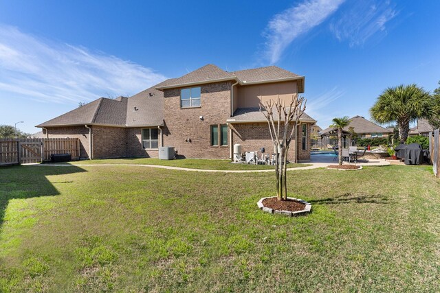 back of house with brick siding, a yard, a patio, a gazebo, and a fenced backyard